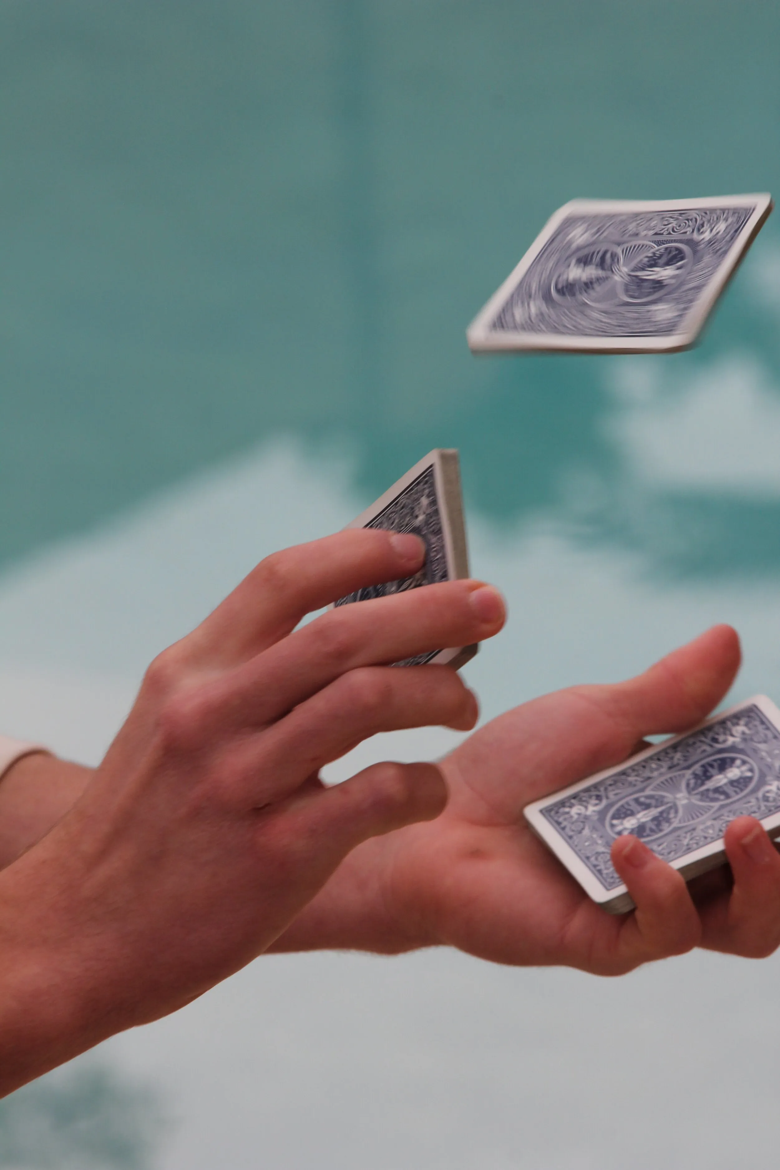 Hands tossing playing cards into the air